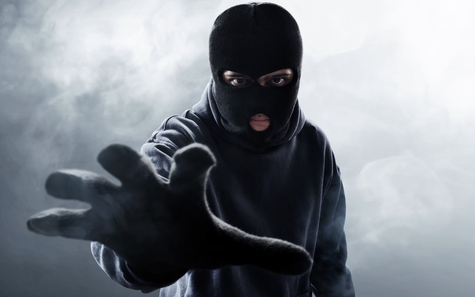 Foto von einer Person mit Maske die nach etwas greift